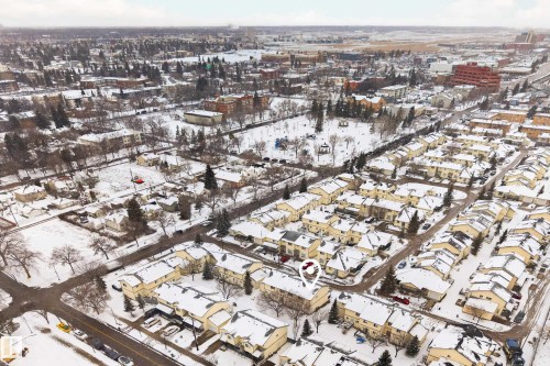 Aerial view of the property and its surrounding residential neighborhood, featuring snow-covered rooftops and trees - 9 10909 106 Street, Edmonton, AB - Outdoor With View