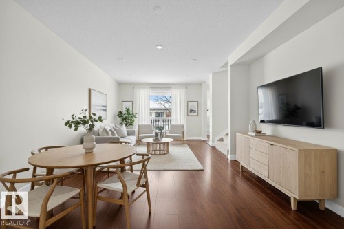 The property features an open-concept living area with dark wood flooring and light-colored walls - 9 10909 106 Street, Edmonton, AB - Indoor Photo Showing Other Room