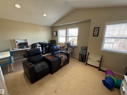 This room features a vaulted ceiling, recessed lighting, and windows with blinds providing natural light - 21113 92A Avenue, Edmonton, AB - Indoor