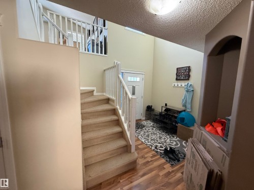 The property features a staircase with carpeted steps and white railings, leading to an upper level also equipped with white railings - 21113 92A Avenue, Edmonton, AB - Indoor Photo Showing Other Room