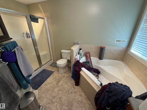 Bathroom featuring a glass-enclosed shower, a built-in corner bathtub, a toilet, and tiled flooring - 21113 92A Avenue, Edmonton, AB - Indoor Photo Showing Bathroom