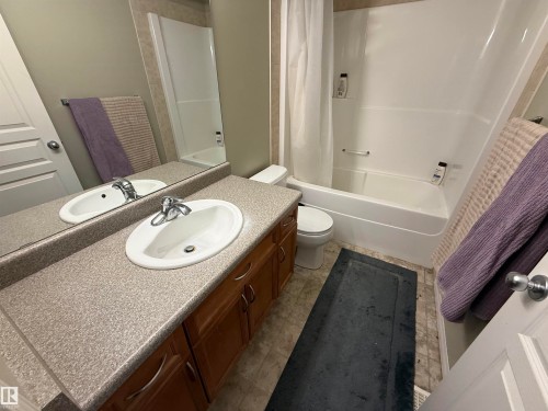 Full bathroom featuring a vanity with a laminate countertop and an integrated sink, a built-in mirror, and a shower-tub combination - 21113 92A Avenue, Edmonton, AB - Indoor Photo Showing Bathroom