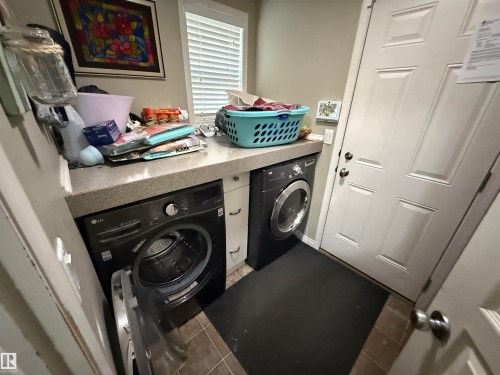 Laundry area featuring a counter with a window, a washer, and a dryer - 21113 92A Avenue, Edmonton, AB - Indoor Photo Showing Laundry Room