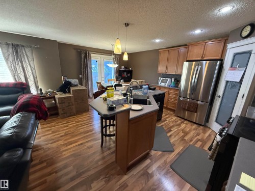 The property features a kitchen with wood cabinetry, stainless steel appliances, and a central island with a sink - 21113 92A Avenue, Edmonton, AB - Indoor Photo Showing Kitchen