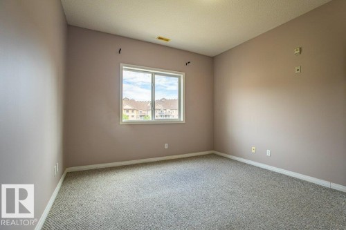 Spacious room featuring neutral carpeting and a window providing natural light - 326 4304 139 Ave, Edmonton, AB - Indoor Photo Showing Other Room