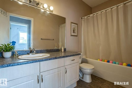 Bathroom featuring a vanity with a counter and sink, a large mirror, and a shower with a curtain - 326 4304 139 Ave, Edmonton, AB - Indoor Photo Showing Bathroom