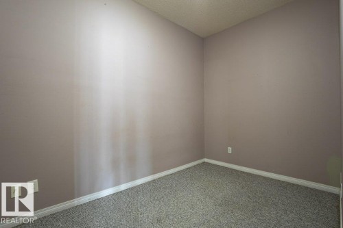 Room featuring textured carpeting, light-colored walls, and white baseboards - 326 4304 139 Ave, Edmonton, AB - Indoor Photo Showing Other Room