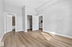Spacious room featuring light wood flooring, white baseboards, and light gray walls - 