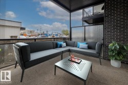 Outdoor patio featuring a black brick exterior wall and a dark metal overhead structure - 