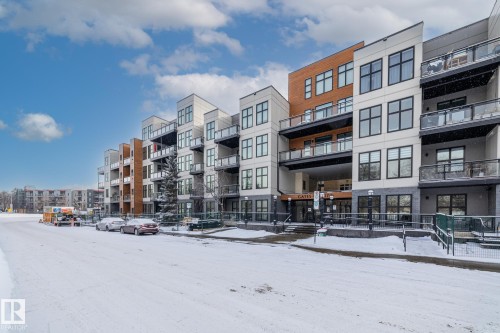 The property features a multi-story building with a modern facade, incorporating light-colored panels and wood-toned accents - 114 10531 117 Street, Edmonton, AB - Outdoor With Facade