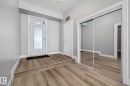 Inviting entryway featuring light-colored hardwood flooring, a white front door with a translucent glass panel, and a mirrored closet with sliding doors - 114 10531 117 Street, Edmonton, AB  - Indoor Photo Showing Other Room 