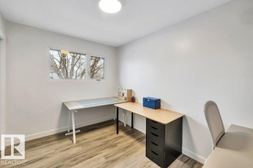 This room features a window providing natural light, light-colored walls, and wood-look flooring - 6719 94B Avenue, Edmonton, AB - Indoor Photo Showing Office