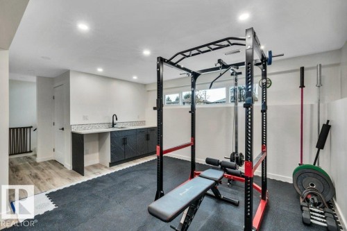 Well-appointed space featuring recessed lighting, a modern wet bar with sink, and durable gym flooring - 6719 94B Avenue, Edmonton, AB - Indoor Photo Showing Gym Room
