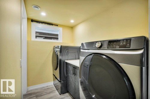Dedicated laundry area with modern appliances and wood-look flooring - 6719 94B Avenue, Edmonton, AB - Indoor Photo Showing Laundry Room