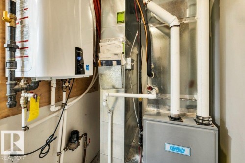 The property features a tankless water heater and a furnace, providing efficient climate control - 6719 94B Avenue, Edmonton, AB - Indoor Photo Showing Basement