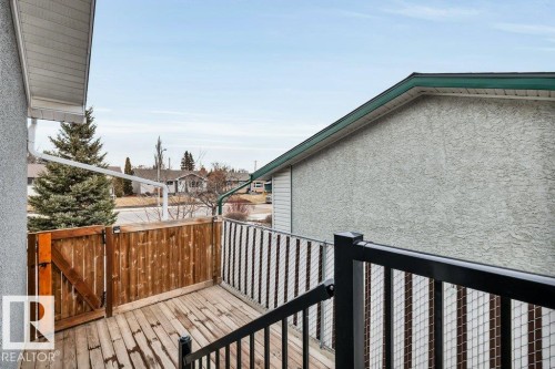 The property features a wooden deck with a privacy fence and black metal railings, offering an outdoor space - 6719 94B Avenue, Edmonton, AB - Outdoor With Exterior