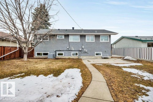 The property features a concrete patio and a paved pathway leading to the rear entrance - 6719 94B Avenue, Edmonton, AB - Outdoor