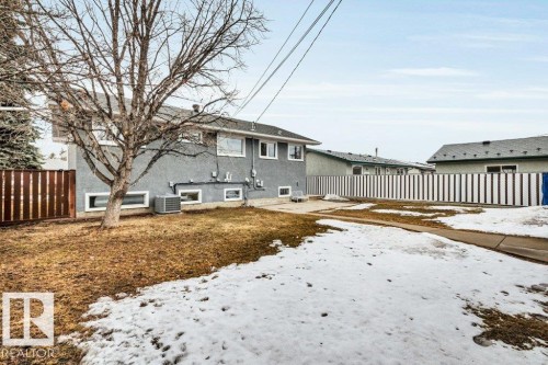 The property features a stucco exterior, a fenced yard, and a paved driveway - 6719 94B Avenue, Edmonton, AB - Outdoor