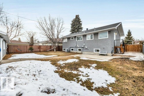 The property features a spacious backyard with a patio, a wooden deck, and a fenced perimeter - 6719 94B Avenue, Edmonton, AB - Outdoor