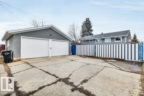 Detached garage with two white garage doors and a paved driveway - 6719 94B Avenue, Edmonton, AB - Outdoor With Exterior