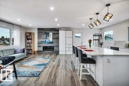 Open concept living area featuring wood-style flooring, recessed lighting, and large windows - 6719 94B Avenue, Edmonton, AB - Indoor