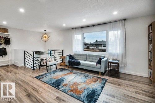 Spacious living area featuring light wood flooring, recessed lighting, and a large window providing natural light - 6719 94B Avenue, Edmonton, AB - Indoor Photo Showing Living Room