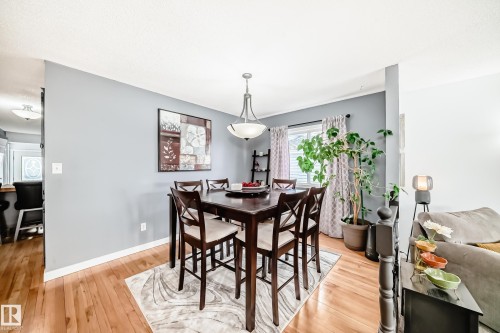 Dining area featuring hardwood floors, a window with blinds and patterned curtains, and a ceiling light fixture - 17819 91A Street, Edmonton, AB - Indoor Photo Showing Dining Room