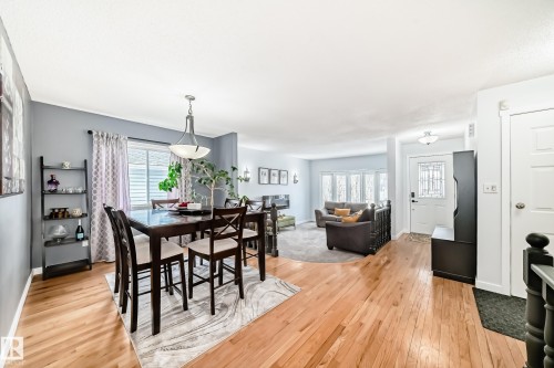 The property features hardwood flooring and a dining area with a contemporary chandelier - 17819 91A Street, Edmonton, AB - Indoor Photo Showing Dining Room
