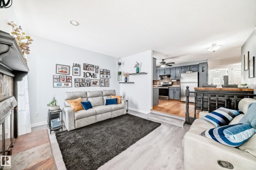 This inviting interior features light-colored walls and flooring, with a dark area rug providing contrast - 17819 91A Street, Edmonton, AB - Indoor Photo Showing Living Room
