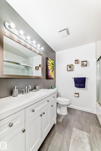 Modern bathroom featuring a vanity with a white countertop, chrome faucet, and white cabinetry with round chrome hardware - 17819 91A Street, Edmonton, AB - Indoor Photo Showing Bathroom