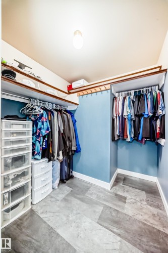 The closet features built-in shelving, clothing rods, and light blue walls - 17819 91A Street, Edmonton, AB - Indoor With Storage