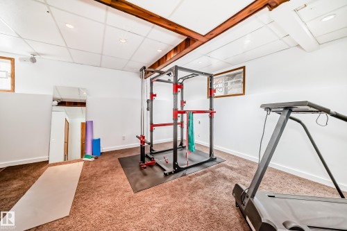 Versatile room featuring carpeted flooring, white walls, exposed wooden beams, and a drop ceiling with recessed lighting - 17819 91A Street, Edmonton, AB - Indoor Photo Showing Gym Room