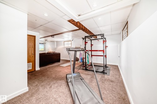 The property features a finished room with carpeted flooring, white walls, and a drop ceiling with recessed lighting - 17819 91A Street, Edmonton, AB - Indoor