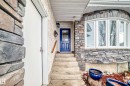 The property features an exterior with stone accents, a deep blue front door with a decorative glass insert, and a bay window - 17819 91A Street, Edmonton, AB  - Outdoor 