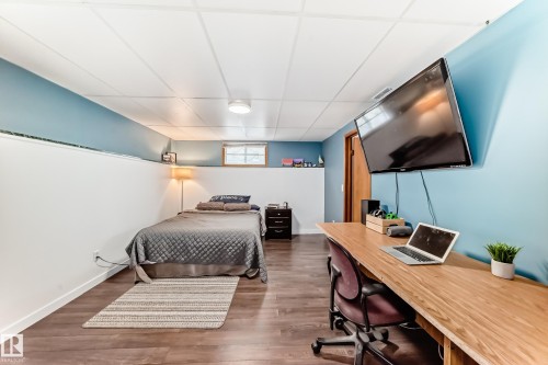 This room features wood-look flooring, a white drop ceiling, and a window providing natural light - 17819 91A Street, Edmonton, AB - Indoor