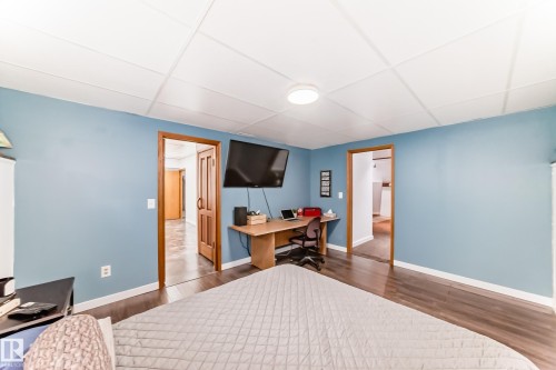 The property features hardwood style flooring, light blue walls, and a white ceiling with recessed lighting - 17819 91A Street, Edmonton, AB - Indoor Photo Showing Bedroom