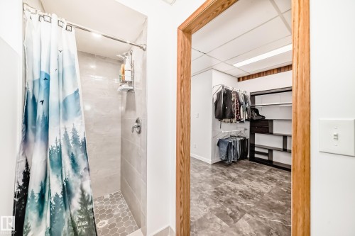 The property features a shower with light-toned tiled walls and a hex-tiled floor - 17819 91A Street, Edmonton, AB - Indoor Photo Showing Bathroom
