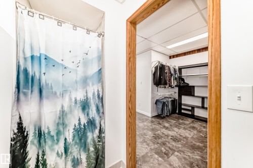 Well-appointed room featuring a custom closet system with shelving and hanging storage, complemented by textured flooring - 17819 91A Street, Edmonton, AB - Indoor Photo Showing Bathroom