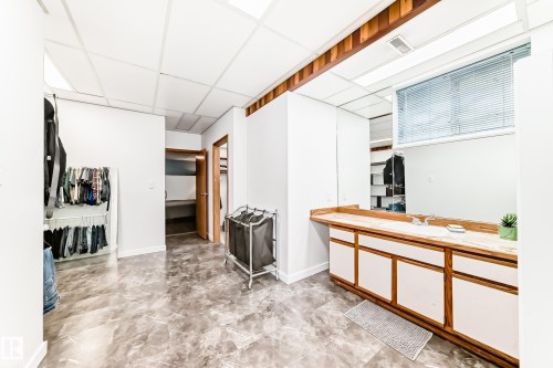 This room features a vanity with a countertop, an integrated sink, and white cabinetry - 17819 91A Street, Edmonton, AB - Indoor
