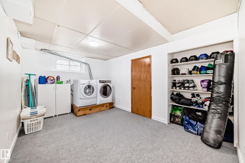 Dedicated laundry area featuring a washer and dryer, built-in shelving, and a window - 17819 91A Street, Edmonton, AB - Indoor Photo Showing Laundry Room