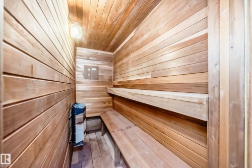 The property features an interior room with natural wood paneling on the walls, ceiling, and floor, complete with built-in wooden benches and a wall-mounted heater unit - 17819 91A Street, Edmonton, AB - Indoor Photo Showing Other Room