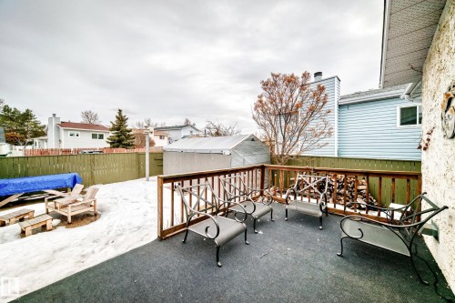 The property features a deck with a dark surface and a wooden railing, providing an outdoor living space - 17819 91A Street, Edmonton, AB - Outdoor