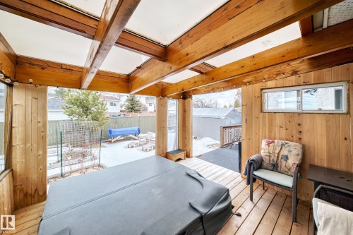 The property features a spacious wooden deck with an exposed beam ceiling, a hot tub, and wood paneling on the walls - 17819 91A Street, Edmonton, AB - Outdoor With Exterior