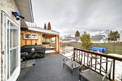 The property features a spacious deck area with a partial wooden enclosure, a wooden railing, and a view of the fenced yard - 17819 91A Street, Edmonton, AB - Outdoor With Exterior