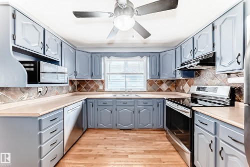 Well-appointed kitchen featuring light blue cabinetry, light-colored countertops, and a tiled backsplash - 17819 91A Street, Edmonton, AB - Indoor Photo Showing Kitchen