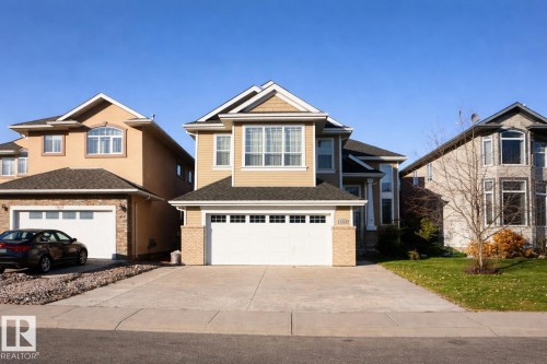 The property features a two-story design with light-colored siding, a dark roof, and an integrated two-car garage with a white door - 6712 18 Ave Sw Sw, Edmonton, AB - Outdoor With Facade