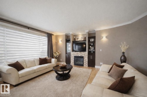 Living area with light-colored flooring and a large area rug - 6712 18 Ave Sw Sw, Edmonton, AB - Indoor Photo Showing Living Room With Fireplace