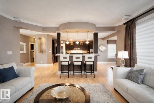 This spacious interior features light wood flooring and neutral wall tones, with recessed lighting and crown molding - 6712 18 Ave Sw Sw, Edmonton, AB - Indoor Photo Showing Living Room