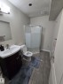 This bathroom features a contemporary vanity with a white sink, a corner glass-enclosed shower, and tile flooring - 3311 21 Street, Edmonton, AB  - Indoor Photo Showing Bathroom 