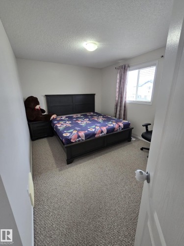 This room features carpeting, a window with blinds, and an overhead light fixture - 3311 21 Street, Edmonton, AB - Indoor Photo Showing Bedroom